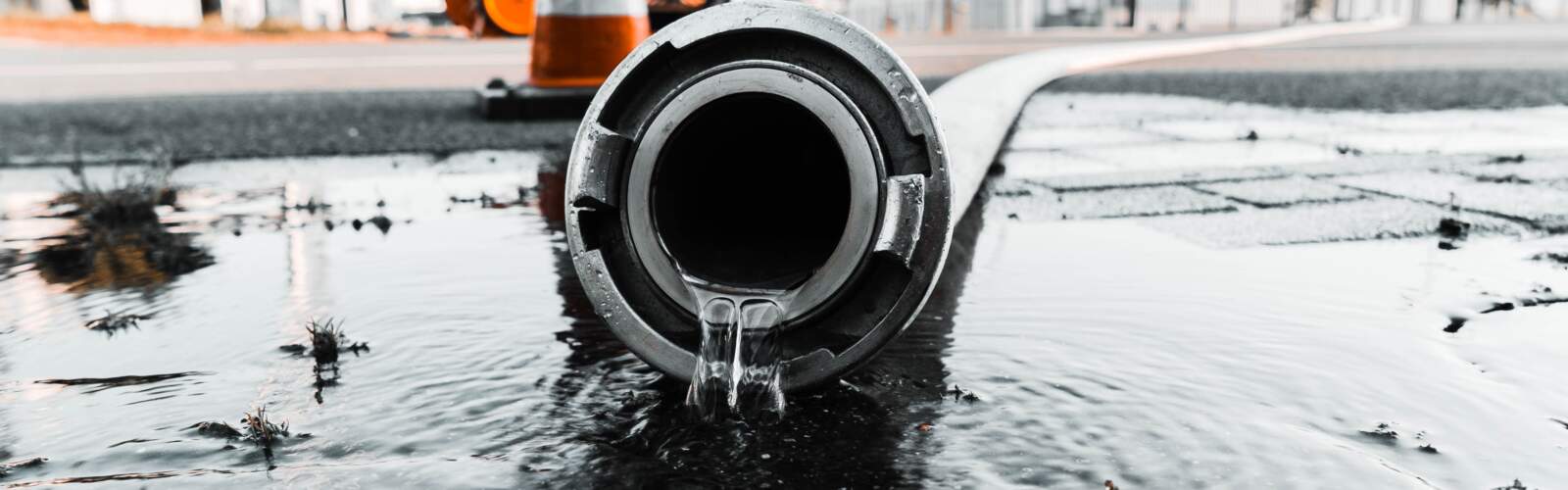 Gray pipe with water coming out its hole